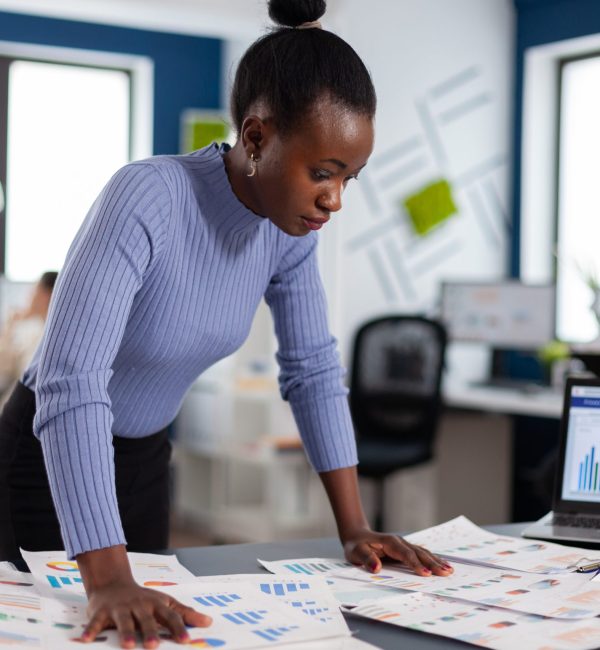 black businesswoman checking work of multiethnic colleagues