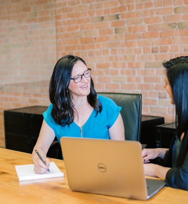 woman-in-teal-t-shirt-sitting-beside-woman-in-suit-jacket-jaovgh5aj3e